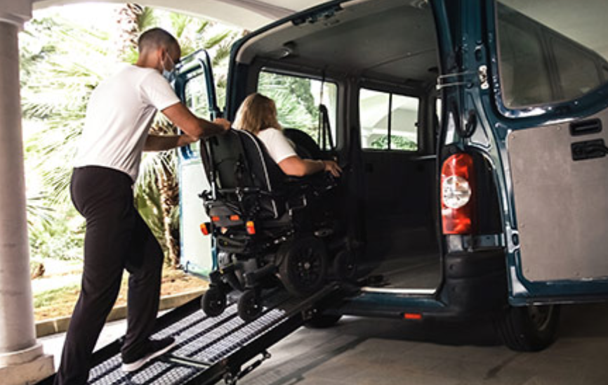 Wheelchair user entering minivan with assistance